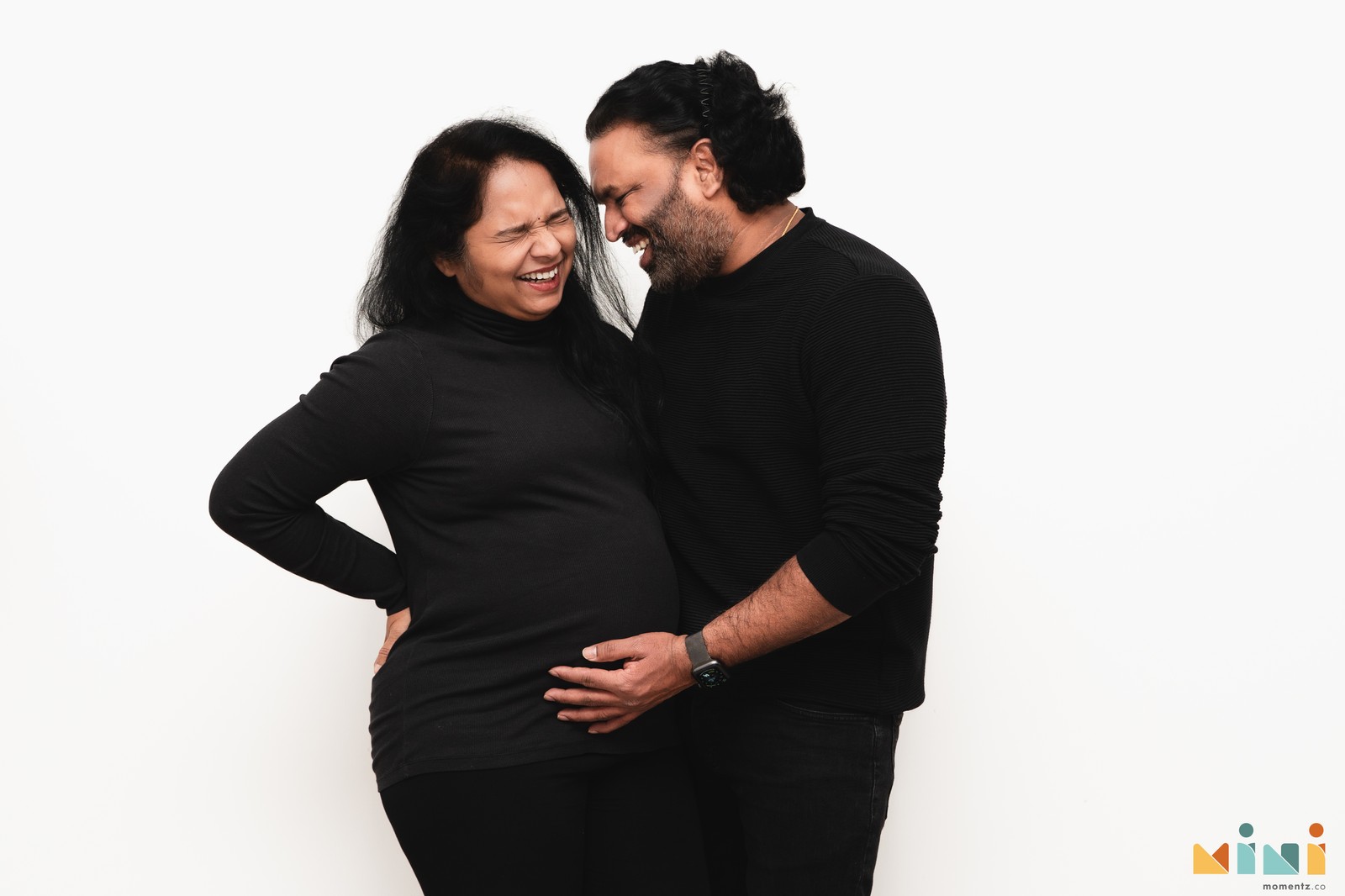 Expecting South Indian couple laughing together during maternity session