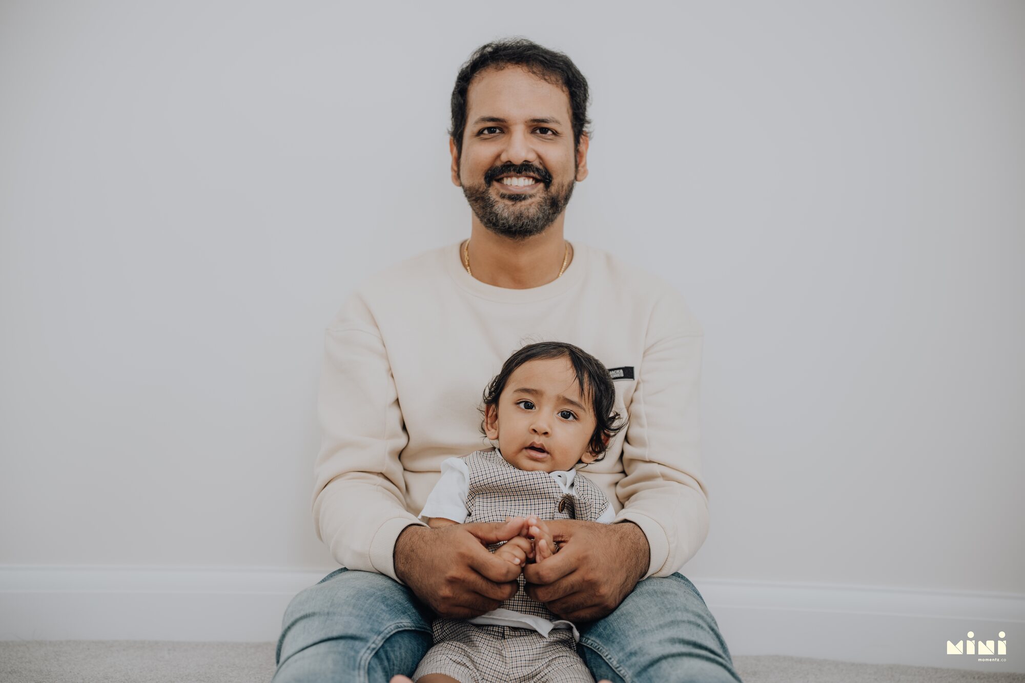 Ramesh holding Sid, seated together — father and son portrait by Mini Momentz family photographer Leicester