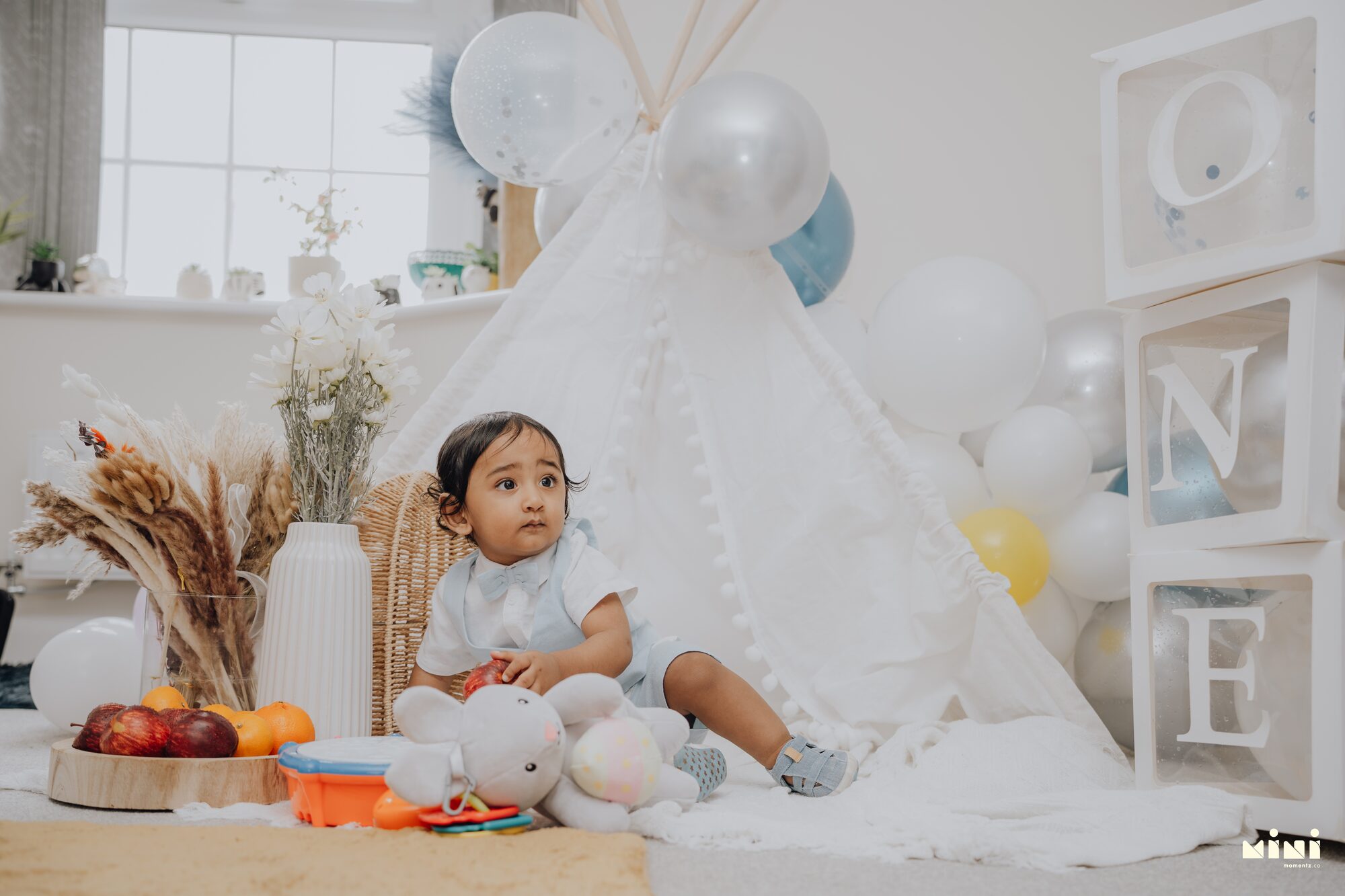 Sid sitting beside a white teepee at his first birthday setup in Barkby Thorpe, Leicester — Mini Momentz